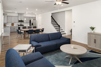 a living room with couches and a table and a kitchen